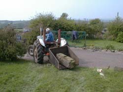 tyle tractor moving old gate post stone into position